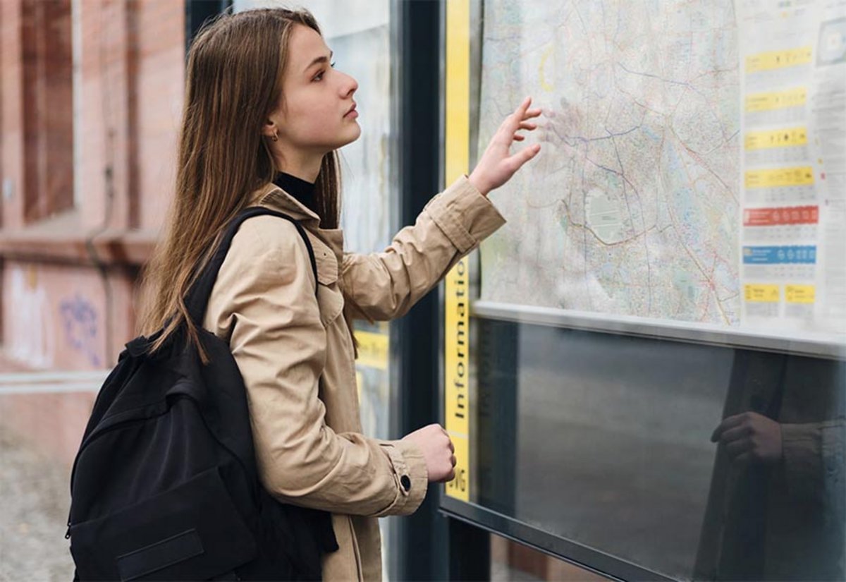 Jeune femme qui consulte une carte des transports dans une ville