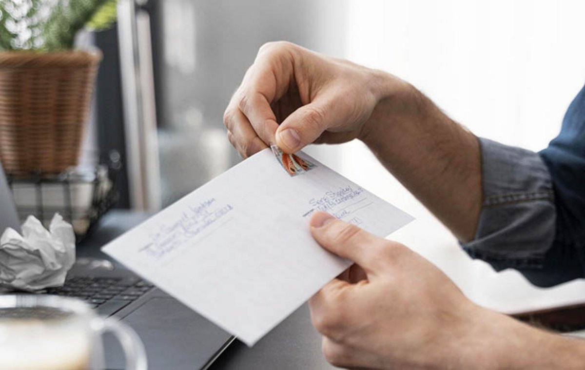 Homme tenant une enveloppe dans ses mains