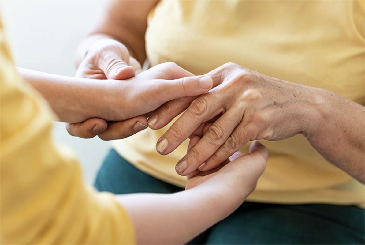 une jeune femme et une femme agée se serrent les mains