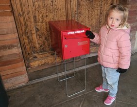 Petite fille à côté de la boite au lettres du Père Noel