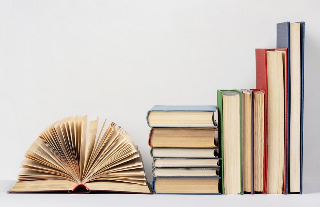 Livres emplilés à côté d'un livre ouvert