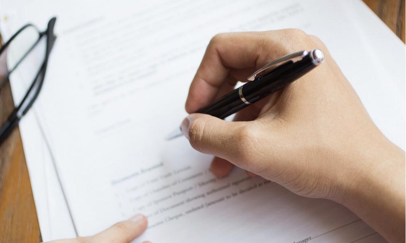 Main tenant un stylo pour signer un document