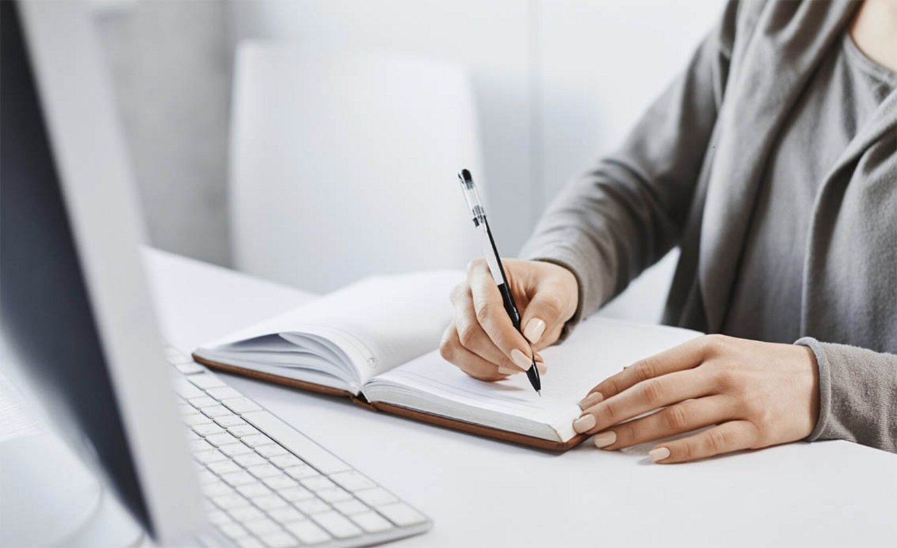 Femme prenant des notes denvant un ordinateur