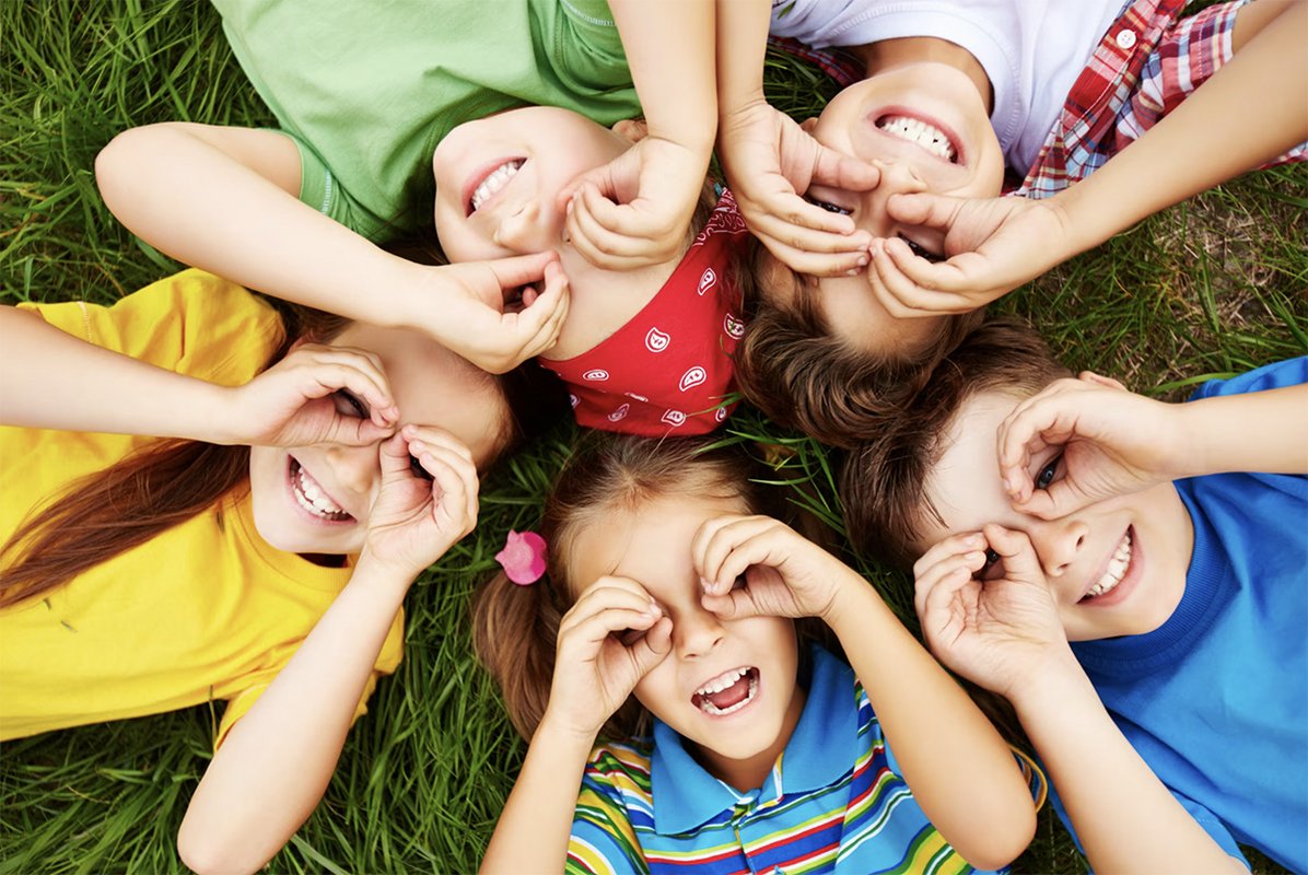 Enfants couchés en rond dans l'herbe